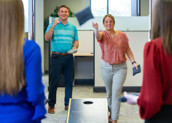 Employees playing cornhole at the office