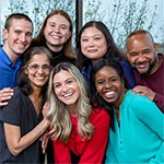 Diverse group of employees in a group smiling at the camera