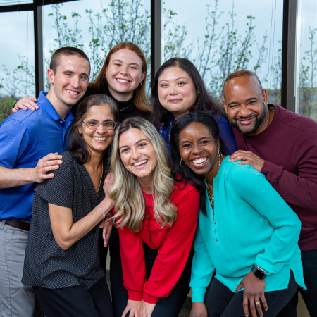 Diverse group of employees in a group smiling at the camera